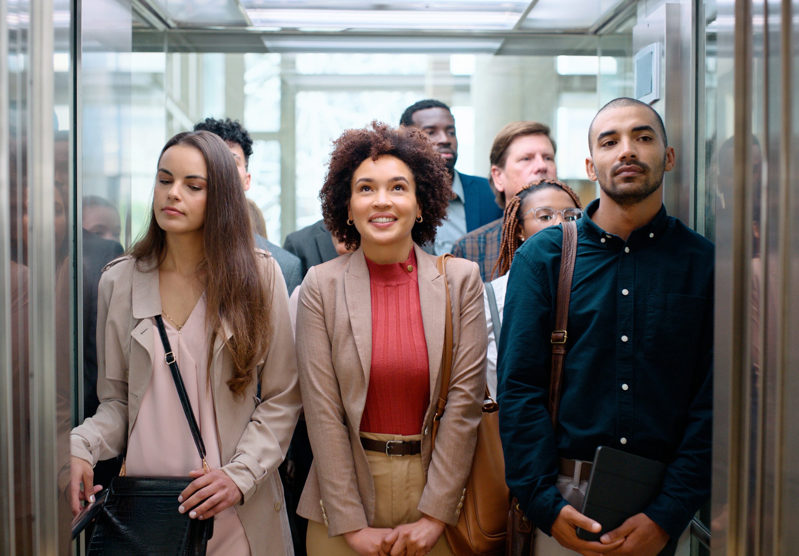 Professionals gather in the interior of an elevator.