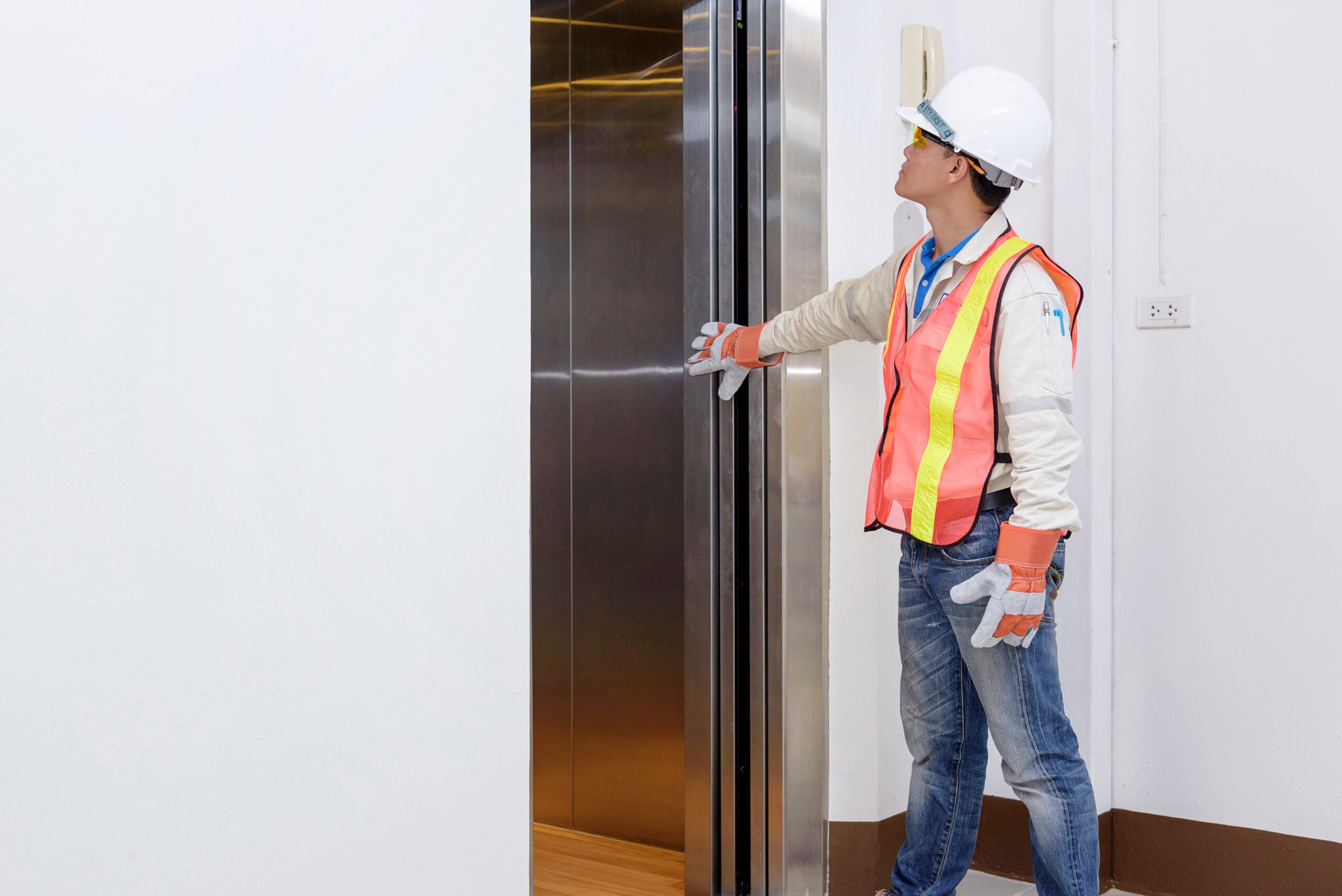 Elevator Technician Inspects Door Lock Monitoring Device.